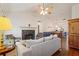 Cozy living room featuring a fireplace, vaulted ceiling, hardwood floors, and open dining area at 2395 Holly Branch Dr, Cumming, GA 30040
