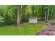 View of backyard featuring a storage shed set among mature trees and landscaping at 270 Park Bridge Ln, Roswell, GA 30075