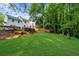 Expansive backyard view with lush lawn, mature trees, and a wooden fence, perfect for outdoor enjoyment at 270 Park Bridge Ln, Roswell, GA 30075