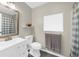 Well-lit bathroom features a vanity with sink, toilet, and tub with shower and checkered curtain at 270 Park Bridge Ln, Roswell, GA 30075