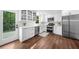 Modern white kitchen featuring stainless appliances, lots of light and a view to a wooded yard at 270 Park Bridge Ln, Roswell, GA 30075