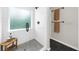 Modern tiled shower with glass door, gray mosaic flooring, bench, and adjacent towel rack at 270 Park Bridge Ln, Roswell, GA 30075