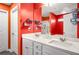 Bathroom featuring double sink vanity with modern faucets and vibrant orange walls at 510 Curry Ridge Ct, Locust Grove, GA 30248