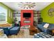 Cozy living room with a red accent wall, fireplace, large ceiling fan, and comfortable seating for relaxing at 510 Curry Ridge Ct, Locust Grove, GA 30248