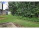 Spacious backyard featuring a lush green lawn, mature trees, and a fence for privacy and security at 6076 Chupp Way Ln, Lithonia, GA 30038