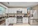 Updated kitchen with stainless steel appliances, white cabinets, and granite countertops at 6076 Chupp Way Ln, Lithonia, GA 30038