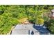 An aerial view of the house showing the gray roof and a wooden deck with chairs and fire pit surrounded by lush trees at 1048 Indian Hills Pkwy, Marietta, GA 30068