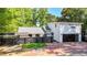 Modern home with black privacy fence, gray roof, brick driveway, mature trees and two-car garage at 1048 Indian Hills Pkwy, Marietta, GA 30068