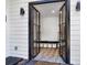 A welcoming entryway with a black framed glass door, shiplap walls, bench, and storage baskets at 1048 Indian Hills Pkwy, Marietta, GA 30068