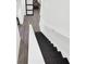 Modern staircase featuring black steps and white risers, complemented by a white handrail and neutral flooring at 1048 Indian Hills Pkwy, Marietta, GA 30068