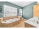 Relaxing bathroom with a large soaking tub, double windows and a neutral color palette at 1107 Park Row South Se, Atlanta, GA 30312