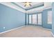 Bright bedroom with a ceiling fan, neutral carpet and paint and three windows at 1107 Park Row South Se, Atlanta, GA 30312