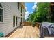 Large wooden deck with BBQ grill, offering great outdoor living space and views of the mature trees at 4108 Wyndam Hill Dr, Suwanee, GA 30024