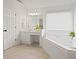 Relaxing bathroom with a soaking tub, vanity with storage, and a bright window at 4108 Wyndam Hill Dr, Suwanee, GA 30024