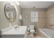 Well-lit bathroom with a soaking tub, a single sink vanity and neutral tiling at 4108 Wyndam Hill Dr, Suwanee, GA 30024