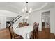 Formal dining room with hardwood floors, wainscoting, decorative chandelier, and staircase to second floor at 4108 Wyndam Hill Dr, Suwanee, GA 30024