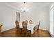 Dining room features wood floors, an elegant chandelier, and six chairs around a dining table with beautiful floral cloth at 4108 Wyndam Hill Dr, Suwanee, GA 30024