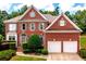 Traditional brick home with a well-manicured lawn and attached two-car garage at 4108 Wyndam Hill Dr, Suwanee, GA 30024