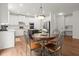 Eat-in kitchen with stainless steel appliances, white cabinets, granite countertops, and hardwood floors at 4108 Wyndam Hill Dr, Suwanee, GA 30024