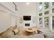 Beautiful living room with built-in shelving, fireplace, large windows offering natural light, and comfortable seating arrangements at 4108 Wyndam Hill Dr, Suwanee, GA 30024