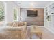 Cozy living room with built-in shelving, wood-paneled wall, and natural light at 4108 Wyndam Hill Dr, Suwanee, GA 30024