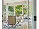 Enclosed sunroom with comfortable seating, a ceiling fan, and views of the lush backyard at 4108 Wyndam Hill Dr, Suwanee, GA 30024