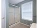 Bathroom features a glass shower door and window that provides natural light at 942 Village View Cir, Loganville, GA 30052