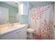 Bathroom features a decorative shower curtain, white vanity, and tile flooring at 942 Village View Cir, Loganville, GA 30052