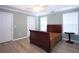 Cozy bedroom features a ceiling fan, wood floors, and natural light from the two windows at 942 Village View Cir, Loganville, GA 30052