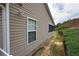 Exterior view of home featuring sunroom, a retaining wall, landscaping and vinyl siding at 942 Village View Cir, Loganville, GA 30052