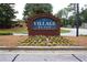 A community sign for The Village Place, nestled in a well-manicured garden at 942 Village View Cir, Loganville, GA 30052