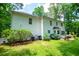 Back of the house with lush green yard, bushes, patio, and two AC units at 97 Coral Dr, Whitesburg, GA 30185