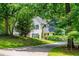 Scenic view of a two-story home surrounded by lush greenery and a sloping front lawn at 97 Coral Dr, Whitesburg, GA 30185