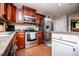 Modern kitchen with stainless steel appliances, cherry cabinets, and ample countertop space at 97 Coral Dr, Whitesburg, GA 30185