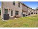 A large backyard with a small patio and table/chairs sits outside a unit's ground floor door at 10151 Benton Woods Dr, Covington, GA 30014