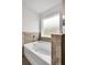 Bathroom with free standing tub and neutral tile backsplash and window at 10151 Benton Woods Dr, Covington, GA 30014
