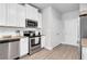 Well-equipped kitchen with stainless steel appliances, white cabinetry, and granite countertops at 10151 Benton Woods Dr, Covington, GA 30014