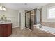 Well-lit bathroom showcasing a glass-enclosed shower, separate tub, and a dark wood vanity with granite countertop at 29 Lankford Rd, Tucker, GA 30084