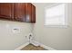 Practical laundry room with wood-look tile floor, cabinets, and washer/dryer hookups at 29 Lankford Rd, Tucker, GA 30084