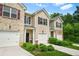 Attractive townhomes featuring attached garages, brick accents, and front yard landscaping at 4076 Sonoma Wood Trl, Decatur, GA 30034