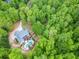 Stunning aerial view of a secluded home with a private pool surrounded by lush greenery and trees at 95 Weslyan Way, Oxford, GA 30054