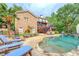 Lush backyard with a freeform pool, stone patio, outdoor seating, and multi-level deck at 95 Weslyan Way, Oxford, GA 30054
