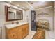 Well-lit bathroom with a wooden vanity, large mirror, and convenient washer and dryer setup at 95 Weslyan Way, Oxford, GA 30054