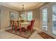 Cozy dining area featuring a chandelier and natural light from the windows and glass doors to the outside at 95 Weslyan Way, Oxford, GA 30054