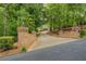 Long driveway leading to a beautiful home, framed by brick pillars and lush greenery at 95 Weslyan Way, Oxford, GA 30054