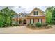 Inviting brick home with manicured landscaping, black shutters, and decorative fountain at 95 Weslyan Way, Oxford, GA 30054