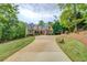 Spacious home featuring a long driveway leading to a beautiful brick facade and manicured lawn at 95 Weslyan Way, Oxford, GA 30054