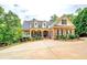 Charming brick home with a welcoming front porch, lush landscaping, and a fountain at 95 Weslyan Way, Oxford, GA 30054