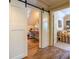Hallway with sliding barn door and access to another room with hardwood floors and natural light at 95 Weslyan Way, Oxford, GA 30054