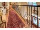 Elegant second floor hallway with decorative railing, hardwood floor and large detailed area rug at 95 Weslyan Way, Oxford, GA 30054